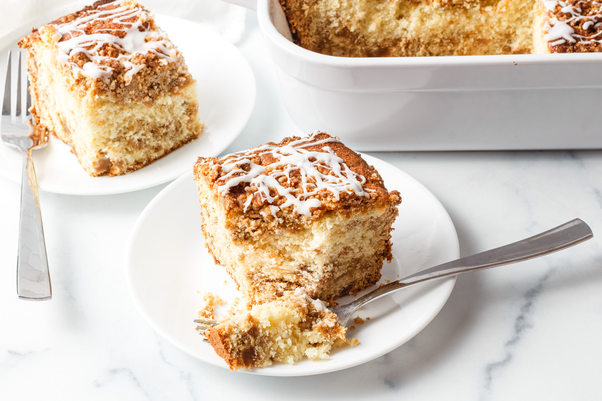 streusel cinnamon coffee cake on a plate on a white neutral background